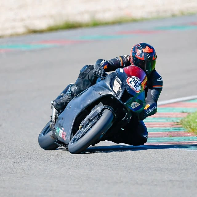Motorradfahrer in tiefer Schräglage auf einem dunkelblauen Sportmotorrad